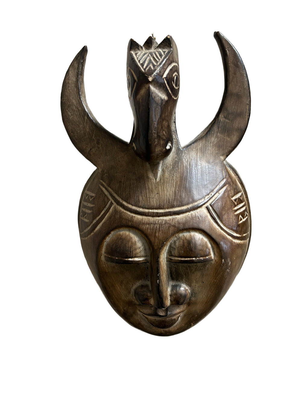 This wood-crafted Art Mask, brilliantly melding metal and wood with bronze and titanium accents, functions as both a fashion accessory and an emblem of artistic expression; its handle enhances its allure, making it a treasured addition for collectors and art enthusiasts, available at the hearing clinic at Allard Audiology.